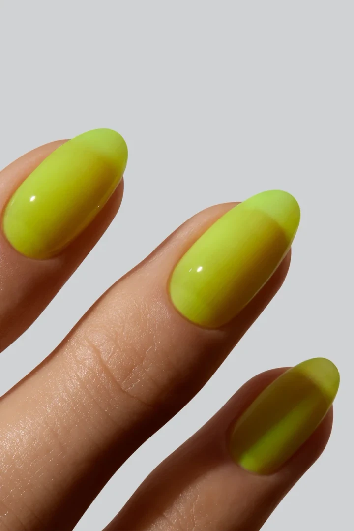 A hand model with perfectly manicured nails showcasing an  attention-grabbing fluorescent yellow.